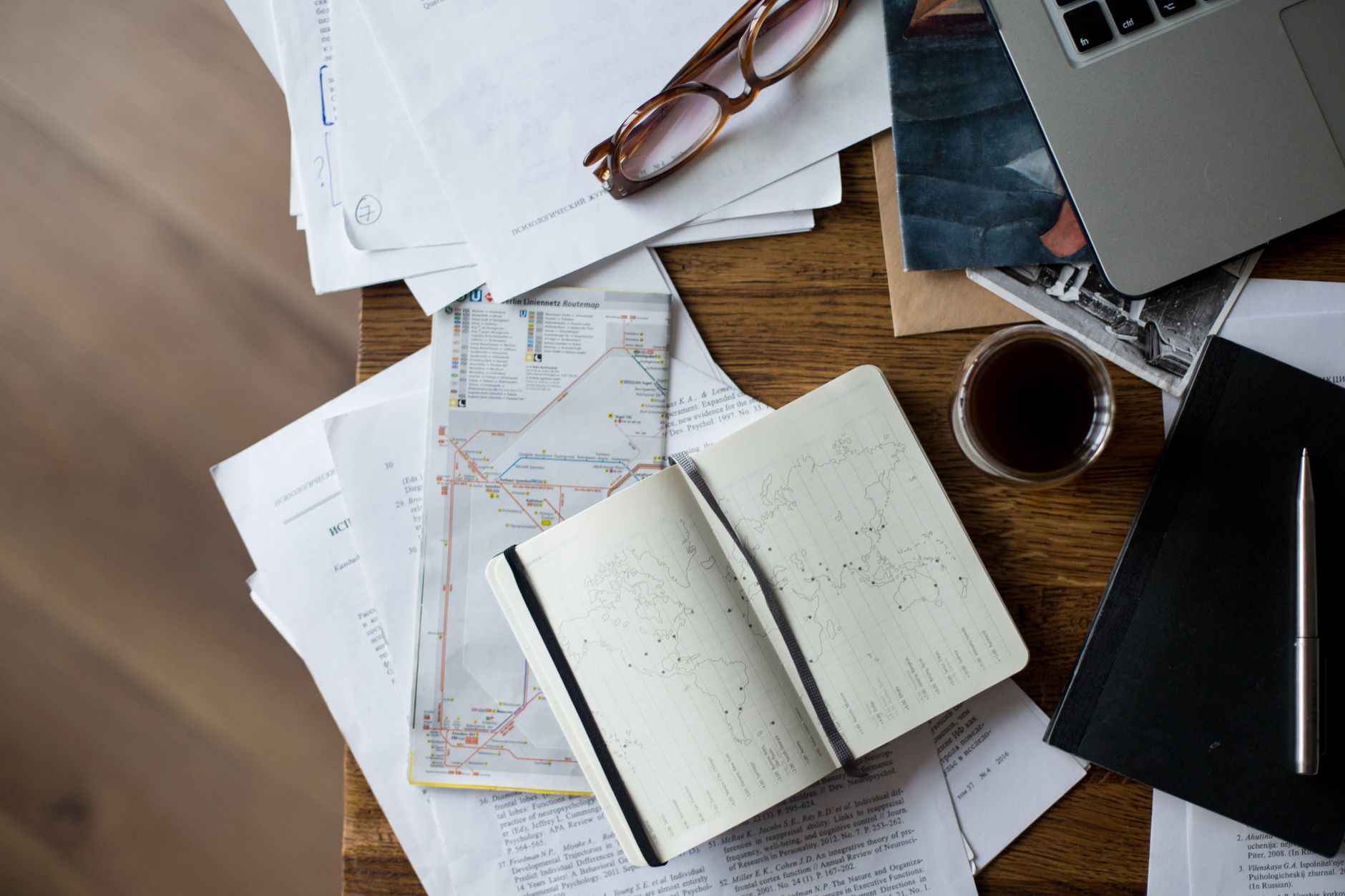 Planificación de itinerarios con cuaderno de viaje y mapas sobre mesa de madera